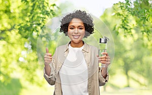 happy woman with drinking water in glass bottle