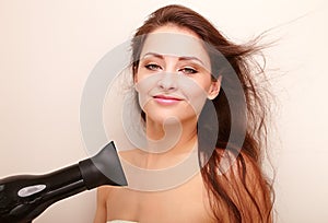 Happy woman drying long brown hair