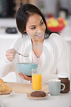 happy woman eating bowl cereal