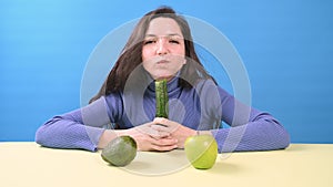 Happy woman eating cucumber with plesure. Healthy eating concept.