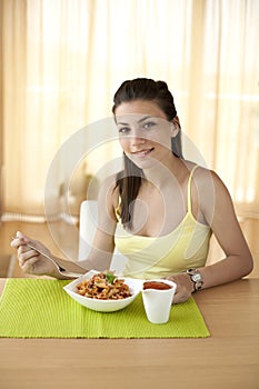 Happy woman eating pasta