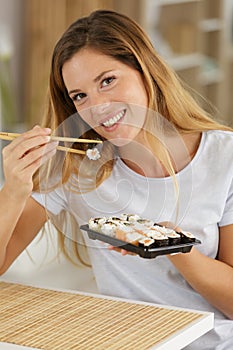 Happy woman eating sushi