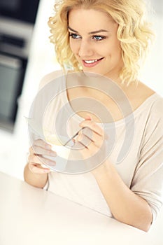 Happy woman eating yogurt