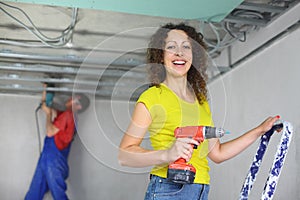 Happy woman with an electric screwdriver and man photo