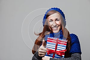 Happy woman embracing a pile of Christmas gifts