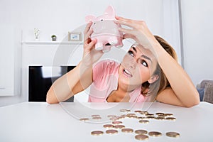 Happy Woman Emptying Her Piggybank Savings