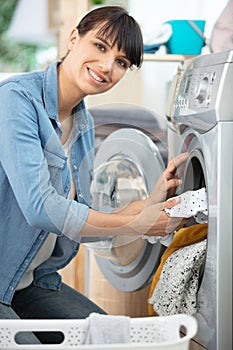 happy woman emptying washing machine