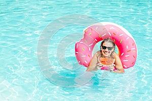 Happy woman enjoy in swimming pool with pink rubber ring