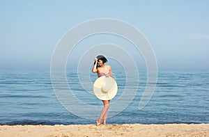 Happy woman enjoying beach relaxing joyful in summer by blue water.