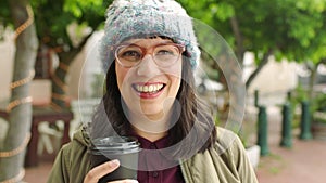 Happy woman enjoying coffee while out traveling in the urban city. Portrait of an edgy young woman wearing glasses and a