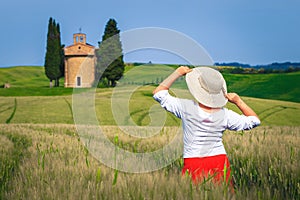 Happy woman enjoying the freedom in grain fields, Tuscany, Italy