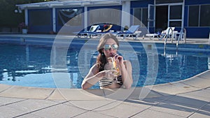 Happy woman enjoying fresh cocktail in water on luxury beach