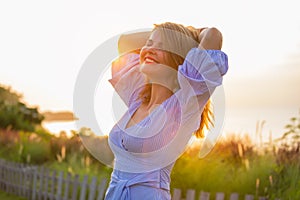 Happy woman enjoying life outdoors at sunset