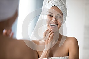 Happy woman enjoying morning skincare routine in bathroom.