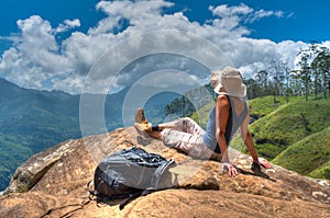 Happy woman enjoying nature on top of mountain cliff