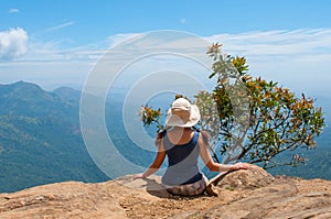 Happy woman enjoying nature on top of mountain cliff