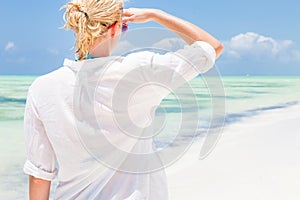 Happy woman enjoying, relaxing joyfully in summer on tropical beach.