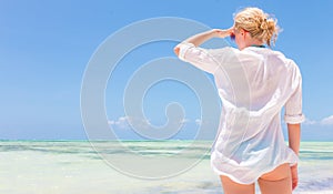 Happy woman enjoying, relaxing joyfully in summer on tropical beach.