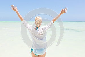 Happy woman enjoying, relaxing joyfully in summer on tropical beach.