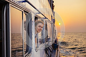 Happy woman enjoying the sea from ferry boat on sunset