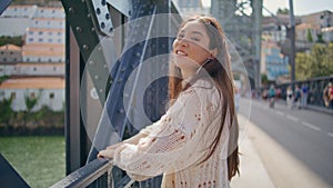 Happy woman enjoying sunlight at city bridge closeup. Asian girl looking camera