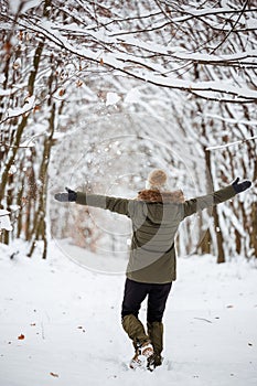 Happy woman enjoying walking in snow at winter nature