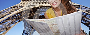 Happy woman exploring attractions in front of Eiffel tower