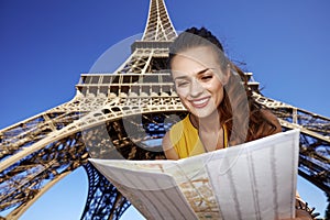 Happy woman exploring attractions in front of Eiffel tower