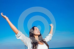 Happy woman with eyes closed at the beach