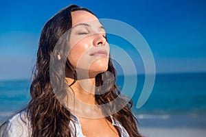 Happy woman with eyes closed at the beach