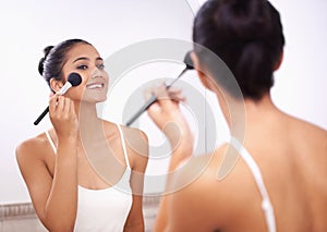 Happy woman, face and makeup brush in mirror for beauty, cosmetics or grooming in bathroom at home. Female person smile