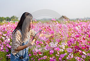 Happy woman farmer owner holding tablet at flower farm for modern farming, technology, agriculture, flower business idea concept