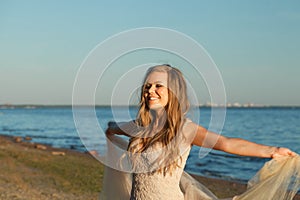 Happy woman feeling free with open arms and breating clean air on sea