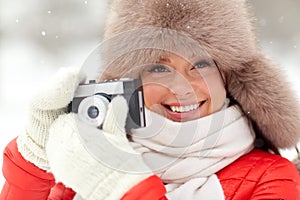 Happy woman with film camera outdoors in winter