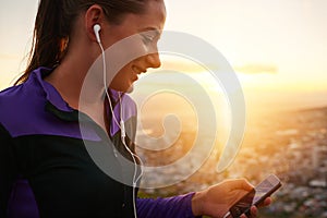 Happy woman, fitness and earphones with phone in sunset for music, podcast or listening to audio in nature. Female