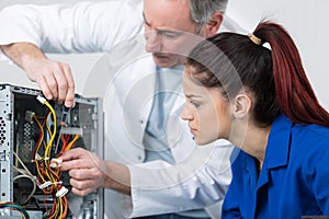 Happy woman fixing computer at desk at work