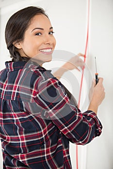 happy woman fixing wall
