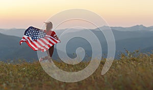 Happy woman with flag of united states enjoying the sunset on na