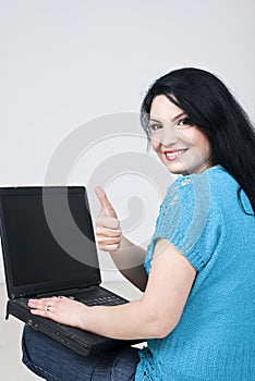 Happy woman on floor with laptop give thumbs