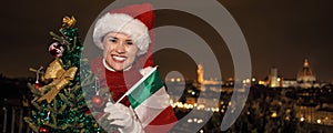 Happy woman in Florence with Christmas tree and Italian flag