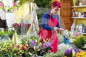 Happy woman florist, making arrangements, and smiling at camera. small business Flower shop owner.