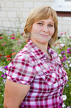 Happy woman with flower relaxes in the grass with a flower.