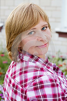 Happy woman with flower relaxes in the grass with a flower.