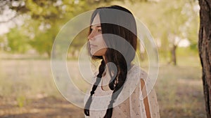 Happy woman in forest enjoying nature. Cute young girl walking outdoors