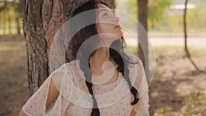 Happy woman in forest enjoying nature. Cute young girl walking outdoors