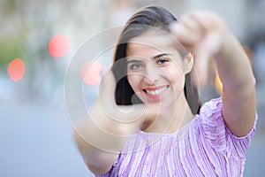 Happy woman framing with hands looking at you