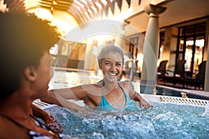 Happy woman, friends and laughing with jacuzzi for funny joke or humor at hotel, resort or hot tub spa together. Face of