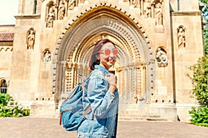 Happy woman in front of The entrance to the Chapel of Jak in Vajdahunyad Castle in Budapest, Hungary