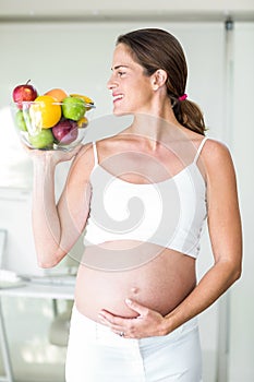 Happy woman with fruit bowl