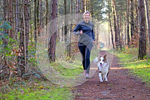 Happy woman full of vitality exercising her dog photo
